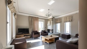 Una sala de estar moderna con televisión de pantalla plana, sofás, una mesa de centro y chimenea.