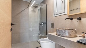 A modern bathroom with a glass-enclosed shower, a marble sink, and a white toilet. - Sea View Suite  First Floor (Nikiana)