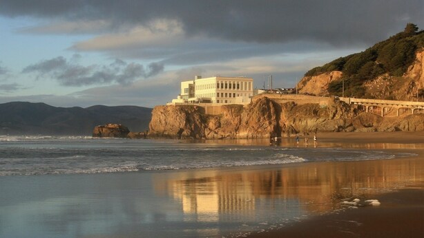 A coastal building with a view of the ocean and a bridge. - The Ocean's Edge Studio (SF)