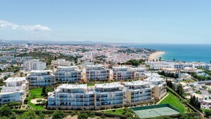 A coastal residential area with modern apartment buildings, a beach, and a clear sky. - BnB Homes Apartment with Sea view 3 Terraces (Albufeira)