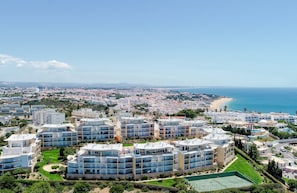 A coastal residential area with modern apartment buildings, a beach, and a clear sky. - BnB Homes Apartment with Sea view 3 Terraces (Albufeira)