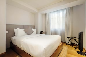 A hotel room with a large bed, a flat-screen TV, and a window with curtains. - w* | Engaging 2BR Retreat in Trendy Roma Norte (Ciudad de México)