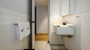 A bathroom with white tiled walls, a sink, a mirror, and a towel rack. - w* | Enchanting 2BR in the Heart of Roma Norte (Ciudad de México)