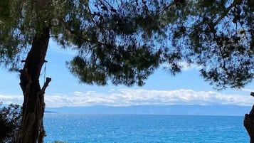 Eine Steinsitzbank mit Blick auf das Meer.