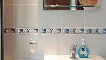 Une salle de bain avec un lavabo blanc, un miroir et des toilettes.