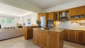 Una cucina moderna con mobili in legno, elettrodomestici in acciaio inossidabile e una grande isola.