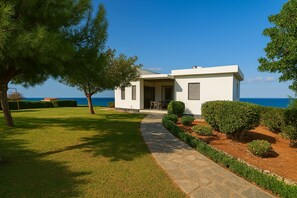 A modern house with a stone pathway leading to a patio area. - Luxury  Villa  Kopsas (Kokkini Hani)