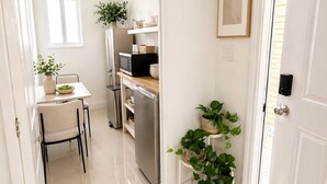 A kitchen with a dining table, chairs, a refrigerator, and a microwave. - Cozy 1-bedroom Room in Serene Princeton with AC comfort (Princeton)
