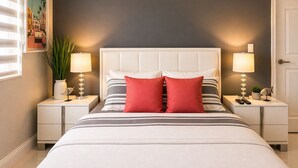 A bedroom with a bed, two bedside tables, a nightstand, a lamp, a wall clock, and a framed picture. - Cozy 1-bedroom Room in Serene Princeton with AC comfort (Princeton)