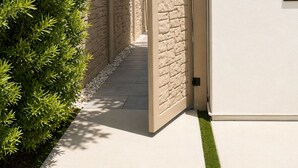 A pathway leading to a building with a stone wall and a white exterior. - Cozy 1-bedroom Room in Serene Princeton with AC comfort (Princeton)