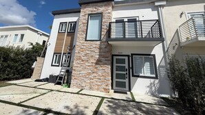 A modern two-story residential building with a stone facade, a balcony, and a visible door number. - Cozy 1-bedroom Room in Serene Princeton with AC comfort (Princeton)