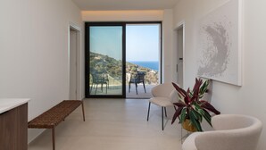 A modern interior with a bench, a chair, and a potted plant. - Luxury  Villa  Verde (Agios Dimitrios Rodias)