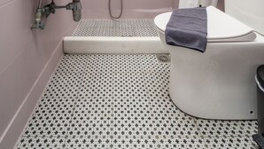 A bathroom with a sink, toilet, shower, and patterned floor tiles. - Hippocampus - Standard Triple Studio (Moutsouna)