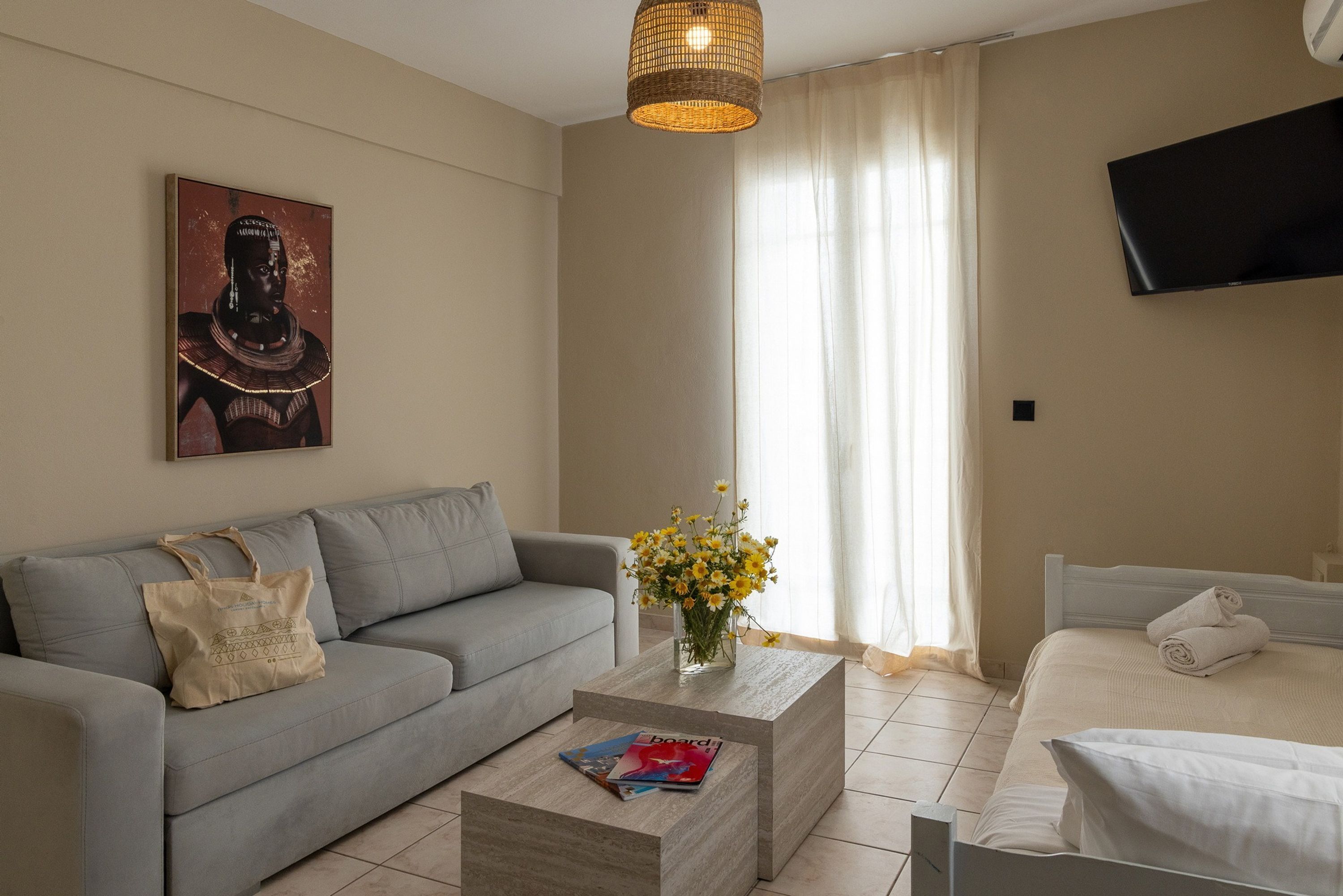 A modern living room with a sofa, coffee table, and a bed.