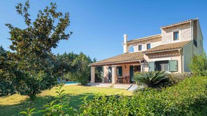 A two-story house with a tiled roof, a covered patio, and a swimming pool in the background. - Villa Lefki Limni Retreat 300m from beach (Corfu)