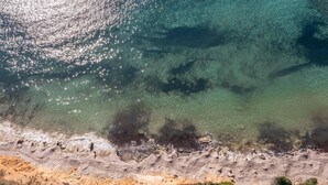 An aerial view of a coastal area with clear waters, rocky shoreline, and a narrow path leading to the beach. - Villa Lefki Limni Retreat 300m from beach (Corfu)