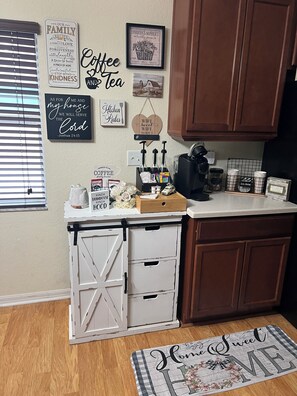 A kitchen with wooden cabinets, a coffee station, and various kitchen items. - Florida Chill
Sunshine by Day, Fire Pit Nights — 3BR with AC in Winter Haven (Winter Haven)