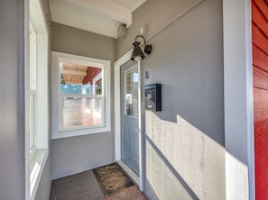 A hallway with a door, a window, and a wall-mounted mailbox. - Riverfront Astoria Condo on Pier, Walk Everywhere (Astoria)