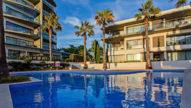 En swimmingpool med en moderne bygning i baggrunden.