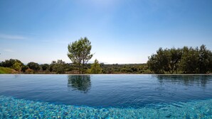 A clear pool with a view of trees and hills in the background. - Villa Ioanna Mentoros (Kefallonia)