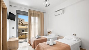 A hotel room with two beds, a TV, a balcony, and a desk. - Park and sea view Villa with Private Pool 2 (Chania)