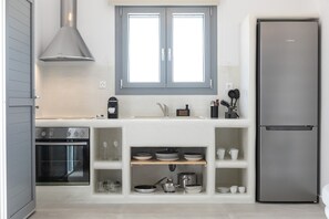 Una cuina moderna amb forn integrat, frigorífic d'acer inoxidable i finestra sobre la bassa.
