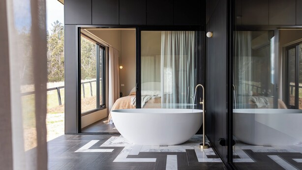 A modern bathroom with a large freestanding bathtub, a glass shower enclosure, and a view of the outdoors. - Barefoot Luxury, Romantic Escapes, Outdoor Bath with a view, Rolling hills (Carlton River)