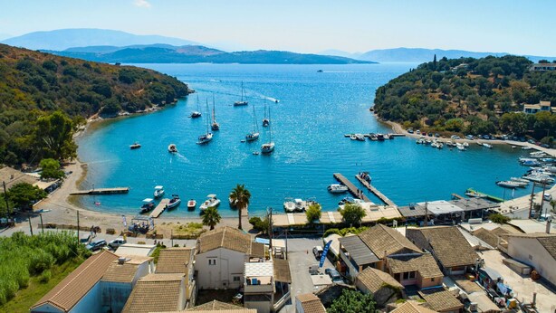 Una località costiera con un porto turistico, imbarcazioni ed edifici residenziali.