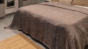 A modern bedroom with a large bed, built-in wardrobe, and a bedside table with a mirror. - Iris - By Celestial Suites (Athina)