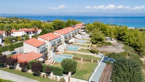 Un resort con diversi edifici, piscine e vista sul mare.