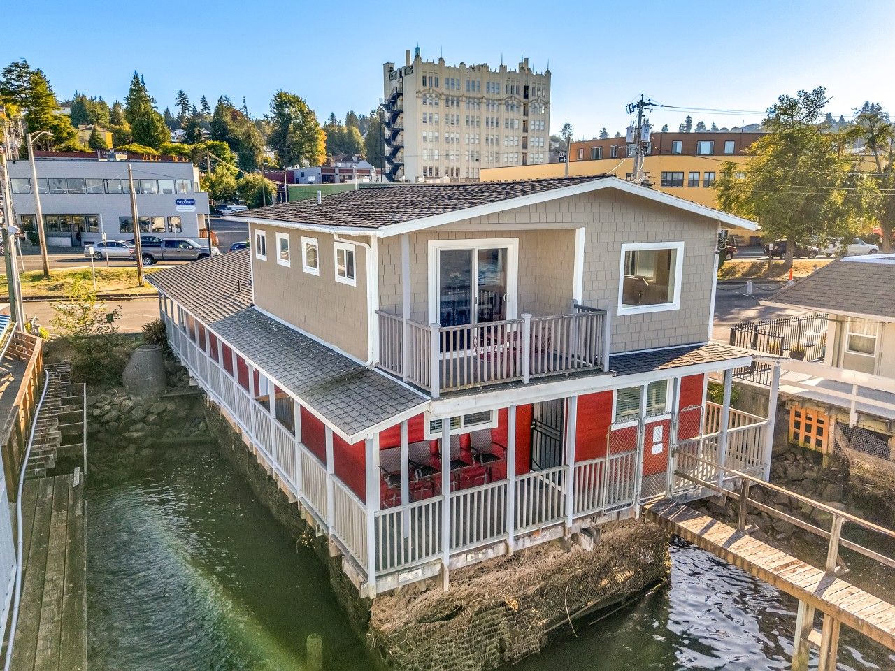 A waterfront house with a balcony, a small deck, and a view of the water.