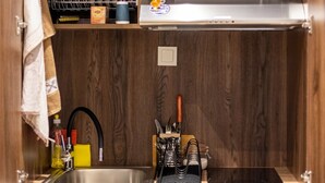 A compact kitchen with a built-in microwave, a small refrigerator, and wooden cabinetry. - Trikala Mall Suites 2nd Floor Suite Number 21 (Trikala)