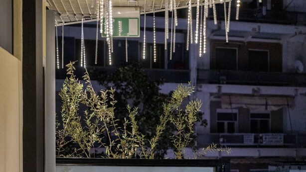 A corridor with a sign for Trikala Mall Suites, a tiled floor, and hanging lights. - Trikala Mall Suites 2nd Floor Suite Number 21 (Trikala)