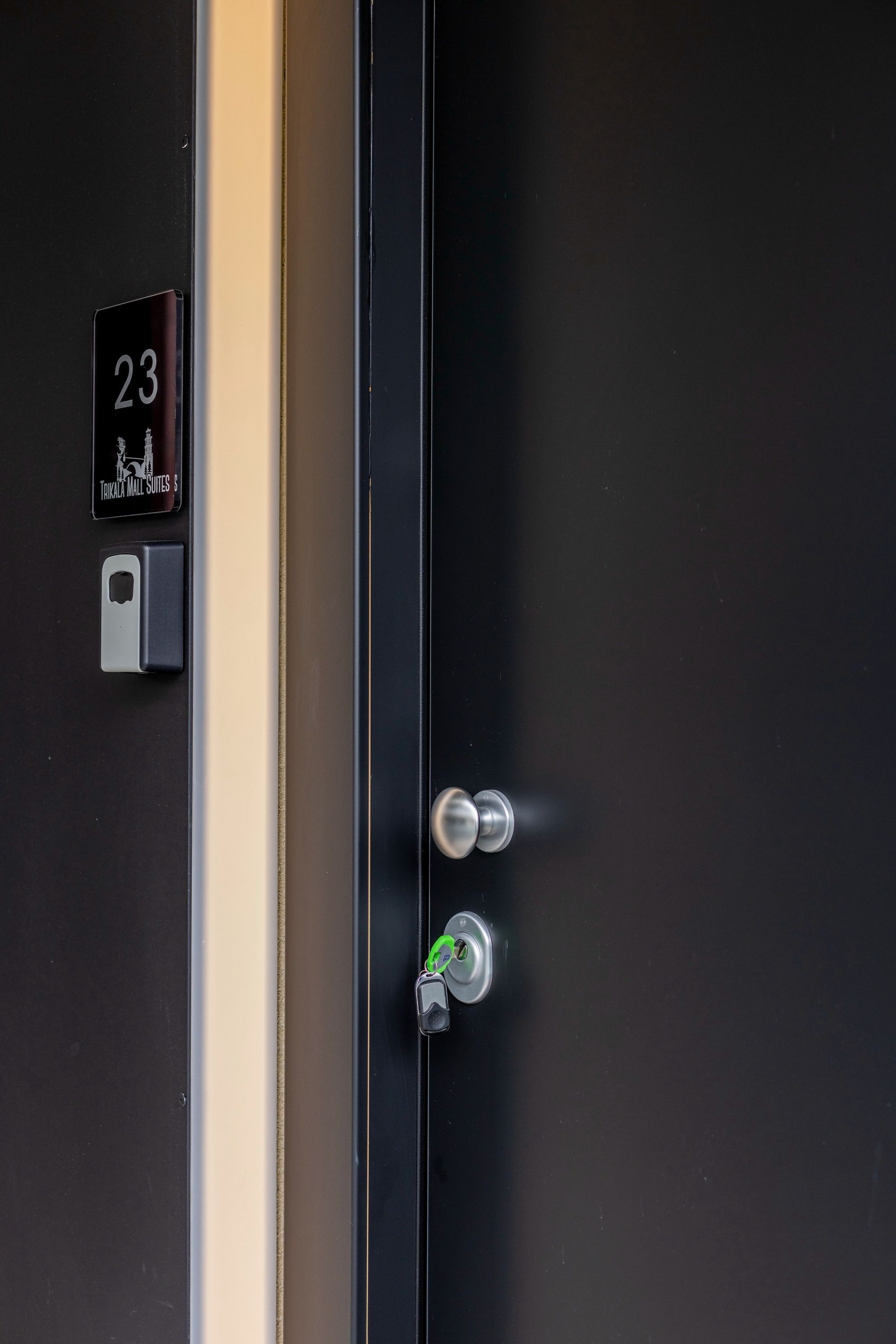 A hotel room door with a number plate indicating room 23, a keyhole, and a key.