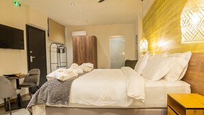 A modern hotel room with a bed, a desk, a chair, a wardrobe, and a ceiling fan.