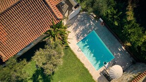 An aerial view of a residential property with a swimming pool, tiled roof, and surrounding greenery. - Villa Ourania Periyali (Zakynthos)