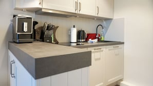 A modern kitchen with white cabinets, a black countertop, and stainless steel appliances. - Fiedler Oase vacation apartment on Sylt - comfort close to the beach (Sylt)