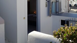 A white building with arched doorways and a sign reading "Rooms Studios Mike". - Studio Orion - AllParos Villas (Paros)