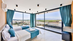A hotel room with a large balcony, two beds, and a view of the airport. - Villa Maranga in Kalkan (Kalkan)