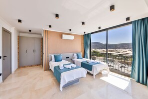 A hotel room with two beds, a balcony with a view, and a large window. - Villa Maranga in Kalkan (Kalkan)
