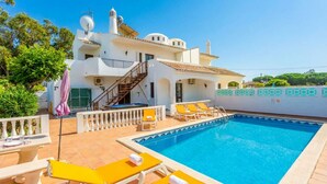 A pool area with lounge chairs, a staircase, and a building with a white facade. - Villa Praia in Albufeira (Albufeira)