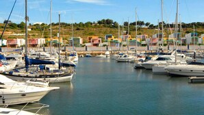 A marina with multiple boats docked, surrounded by a small coastal town with colorful buildings. - Villa Praia in Albufeira (Albufeira)
