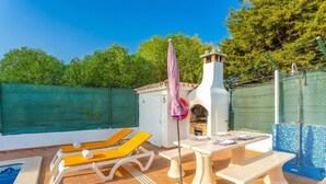 A pool area with lounge chairs, a table, and a covered seating area. - Villa Praia in Albufeira (Albufeira)