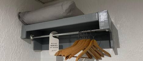 A storage shelf with a pillow and a sign indicating a service room.