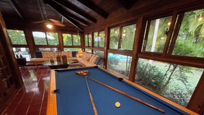 Une table de billard avec un cadre en bois, une queue de billard et une bille de billard.