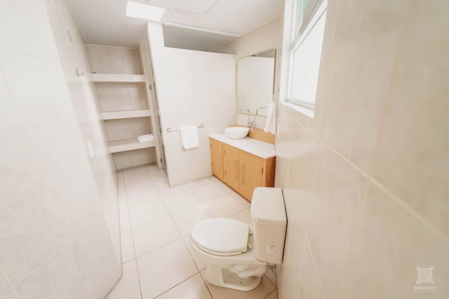 Un bagno con il water, un lavandino e mobili in legno.
