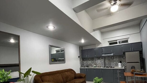 Una cocina moderna con armarios grises, horno empotrado y refrigerador.