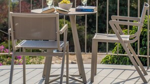 Una terrazza con due sedie, un tavolo e un libro intitolato 'The Wrong Side of the Road'.