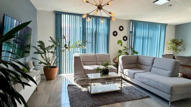 A modern living room with a sofa, a coffee table, and a TV. - AR Suites 3: La Calzada (Zamora de Hidalgo)