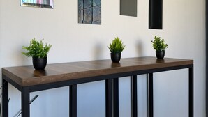 A modern interior with a long wooden table, three potted plants, and three rectangular mirrors on the wall. - AR Suites 4: La Calzada (Zamora de Hidalgo)